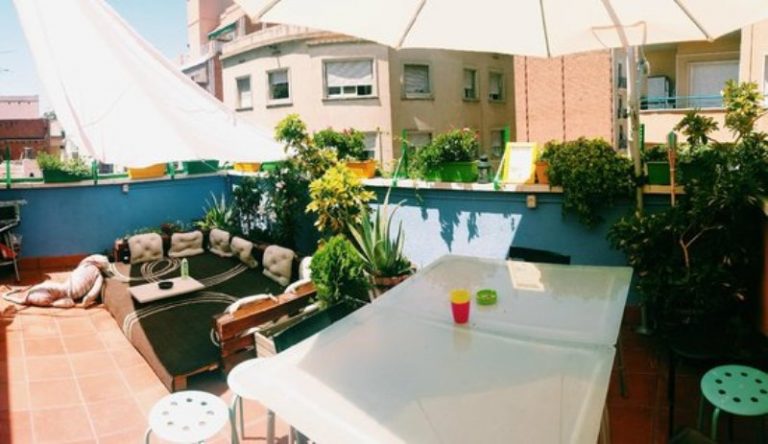A rooftop terrace at Hostel One Sants in Barcelona with lounge seating and city views