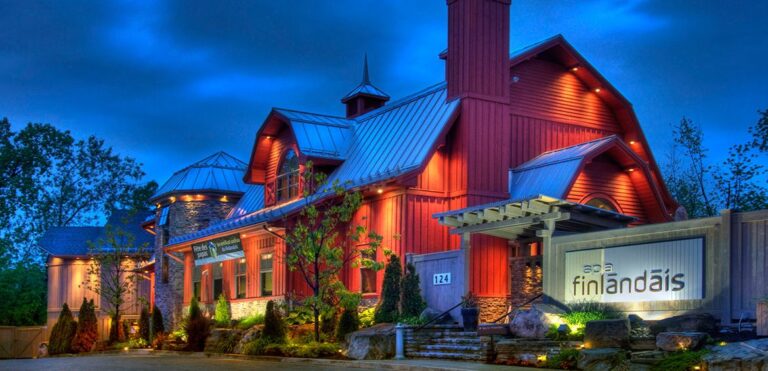 Building and entrance of Spa & Hotel Le Finlandais surrounded by greenery and parking area