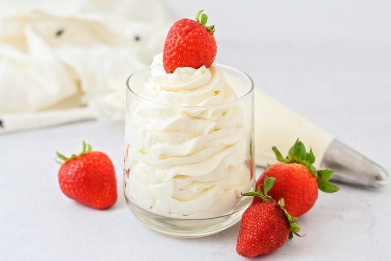Close-up of a whipped cream dispenser and cream chargers on a countertop